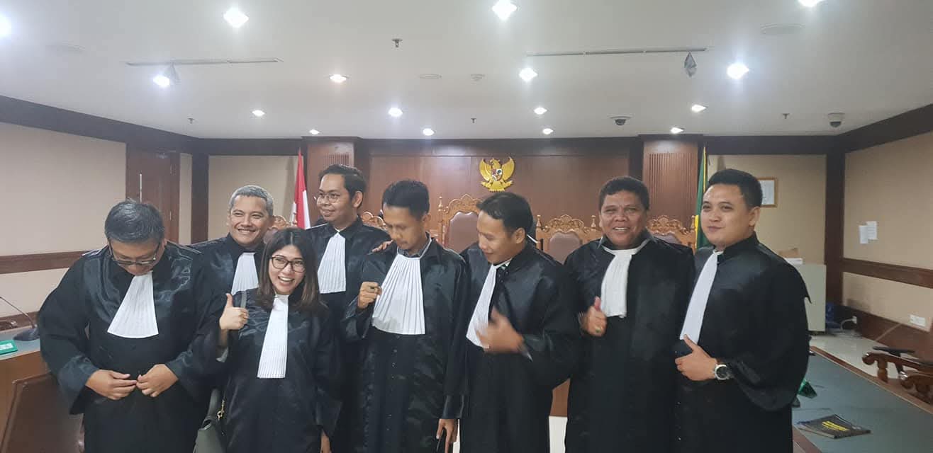 Potret Raymond Simamora, S.H., M.H. (kedua dari kanan) berpose bersama rekan-rekan advokat lainnya dengan mengenakan toga di dalam ruang sidang pengadilan.