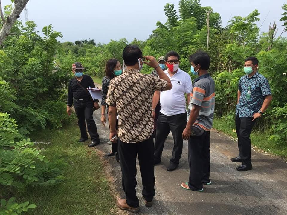 Potret Raymond Simamora, S.H., M.H. bersama warga dan aparat setempat saat melakukan peninjauan lokasi di sebuah jalan pedesaan.